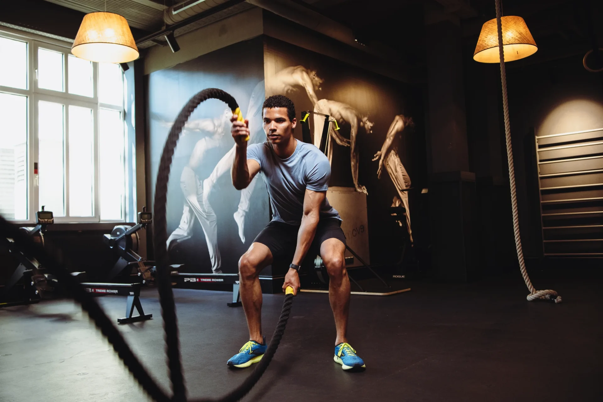 Man training with battle ropes in a functional zone at EVO Fitness